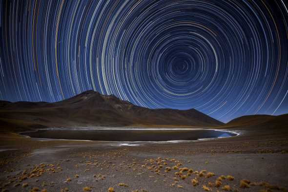 Long-exposure photograph of stars in the sky, tracing circles of light