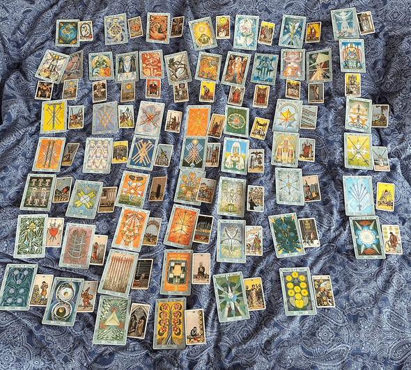 complex grid of tarot cards on a blue paisley bedspread